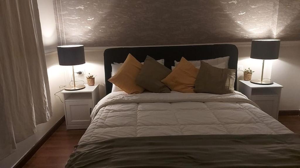 une chambre avec un lit avec des oreillers et deux lampes dans l'établissement شقة بحديقه خاصه, à Sheikh Zayed