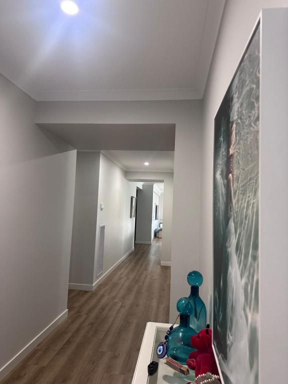 a living room with white walls and a painting on the wall at Serenity in Melton South