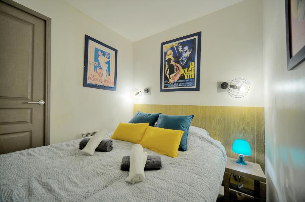 - une chambre avec un lit doté d'oreillers jaunes et bleus dans l'établissement Cannes Beach appartements - Piscine proche mer, à Cannes