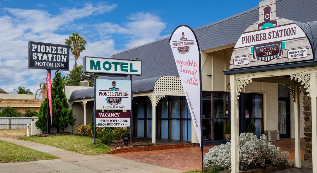 a motel with signs in front of a building at Pioneer Station Motor Inn in Swan Hill