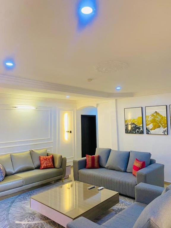 a living room with two couches and a coffee table at Games village Suites in Abuja
