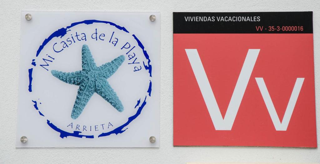 a sign with a starfish next to a sign with awwidents wald at Mi casita de la playa in Arrieta