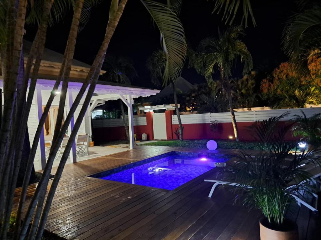 a backyard with a swimming pool at night at Villa SAINT BARTHELEMY in Saint-François