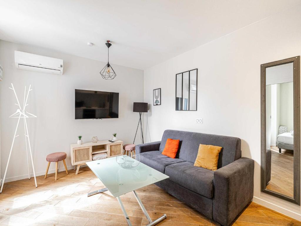 un salon avec un canapé et une table dans l'établissement Charming 1 bedroom apartment- heart of Cannes, à Cannes