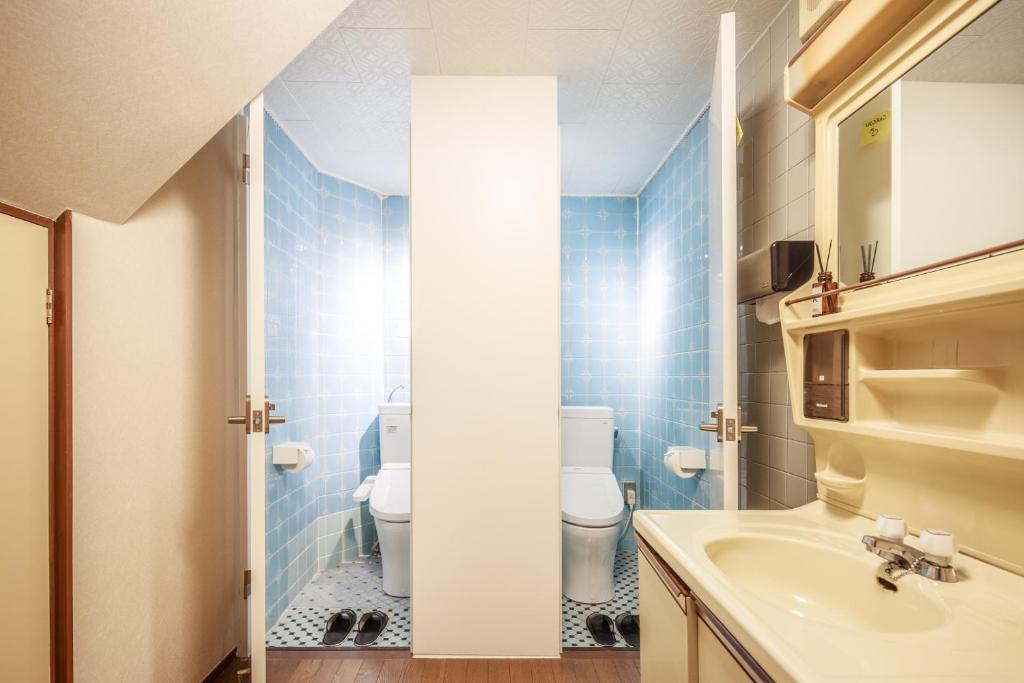 a bathroom with a toilet and a sink at Yadoya Hiraiwa private ryokan in Kyoto