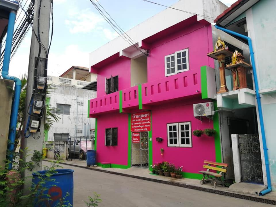 a pink building on the side of a street at Baan Busaya บ้านบุษยา in Ban Khlong Phutsa