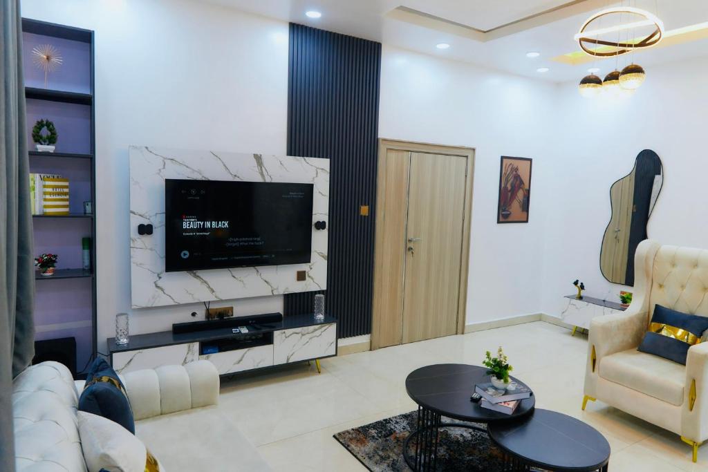 a living room with a couch and a tv at COZY 4BR Duplex shortlet Apartment 4mins to GRA in Port Harcourt