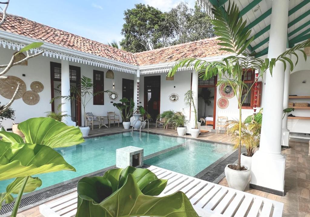 a swimming pool in the courtyard of a house with plants at Marshmellow Surf Camp Sri Lanka in Ahangama