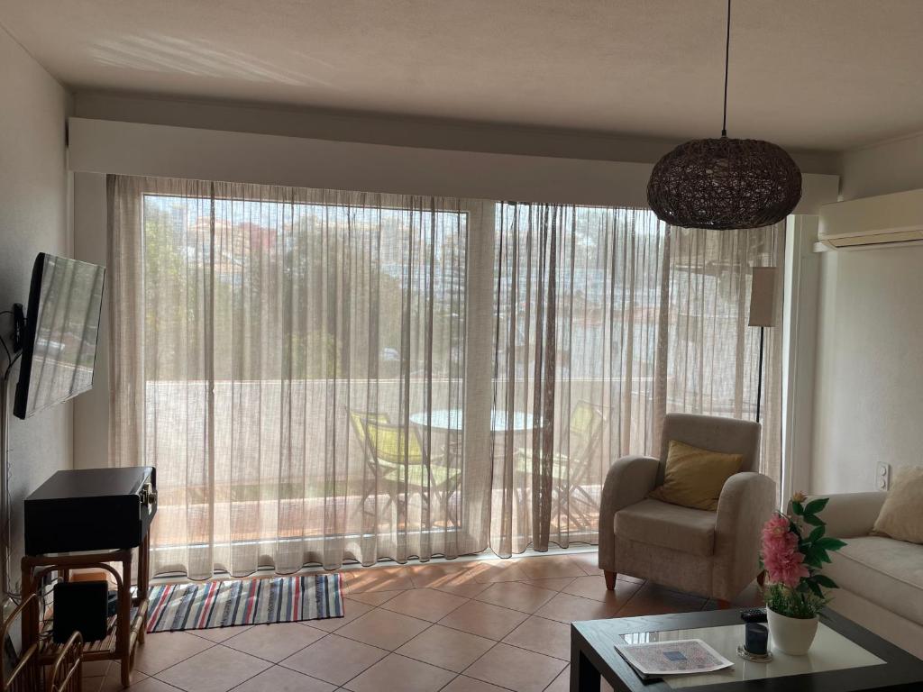 a living room with a large window and a couch at OuraSea Apartment in Albufeira