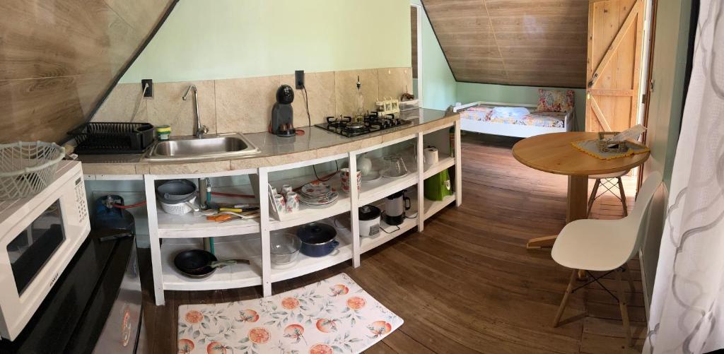 a small kitchen with a sink and a table at Cabaña Vacal Wifi, beach front #2 in Uvita