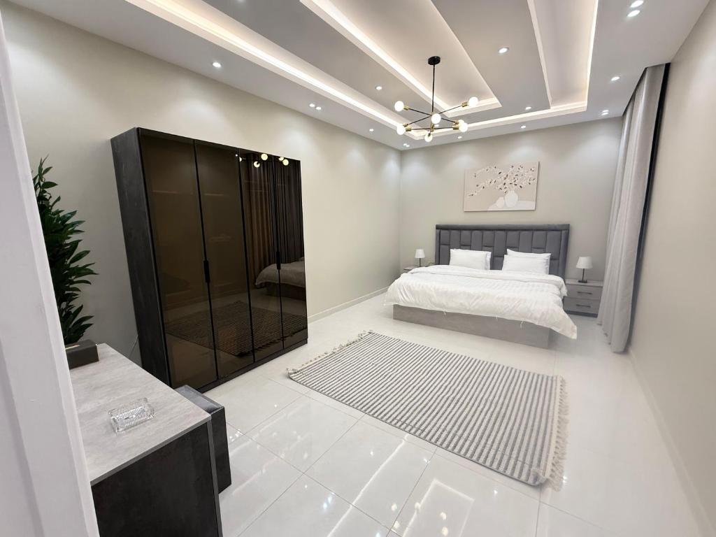 a bedroom with a bed and a walk in shower at مساكن ورد الفندقية in Al Madinah