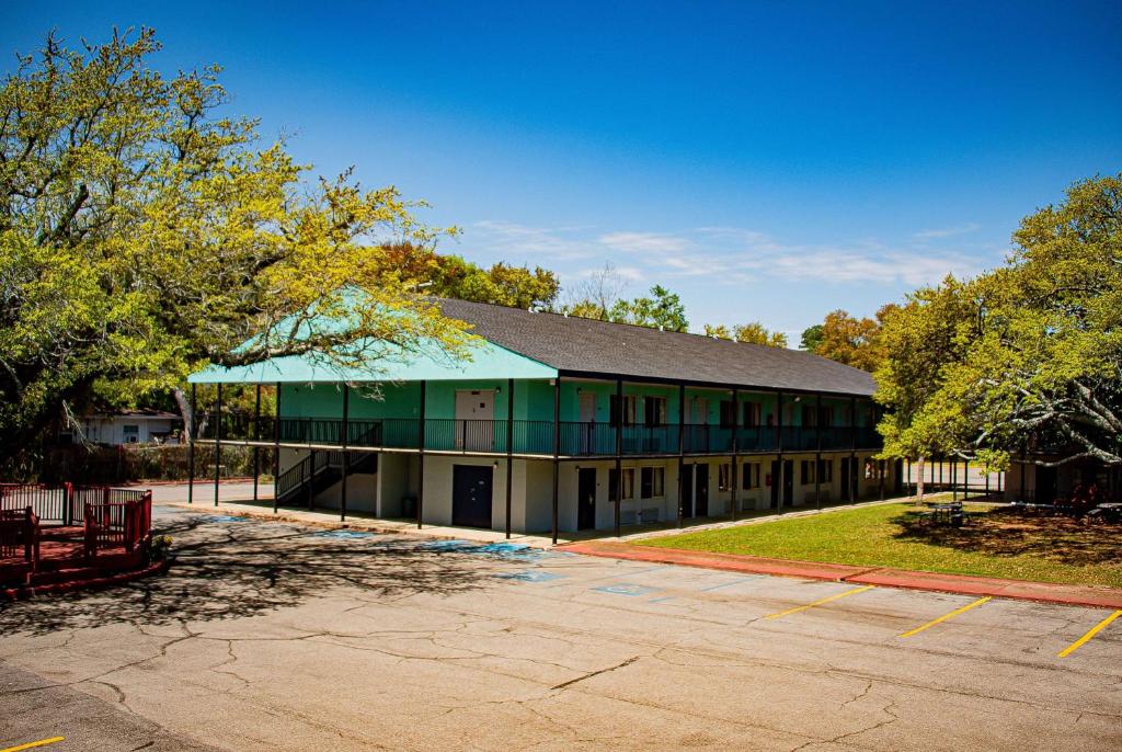 a building with a green roof and a parking lot at Super 8 by Wyndham Biloxi in Biloxi