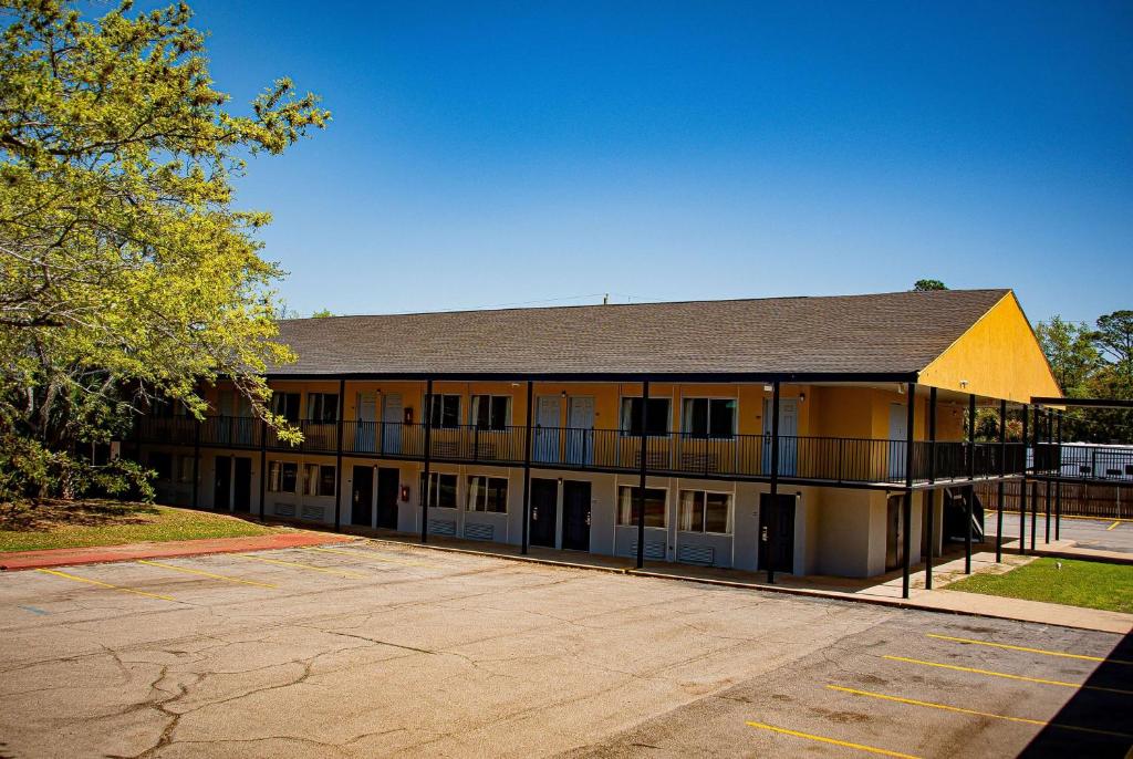 a large yellow building with a parking lot at Super 8 by Wyndham Biloxi in Biloxi