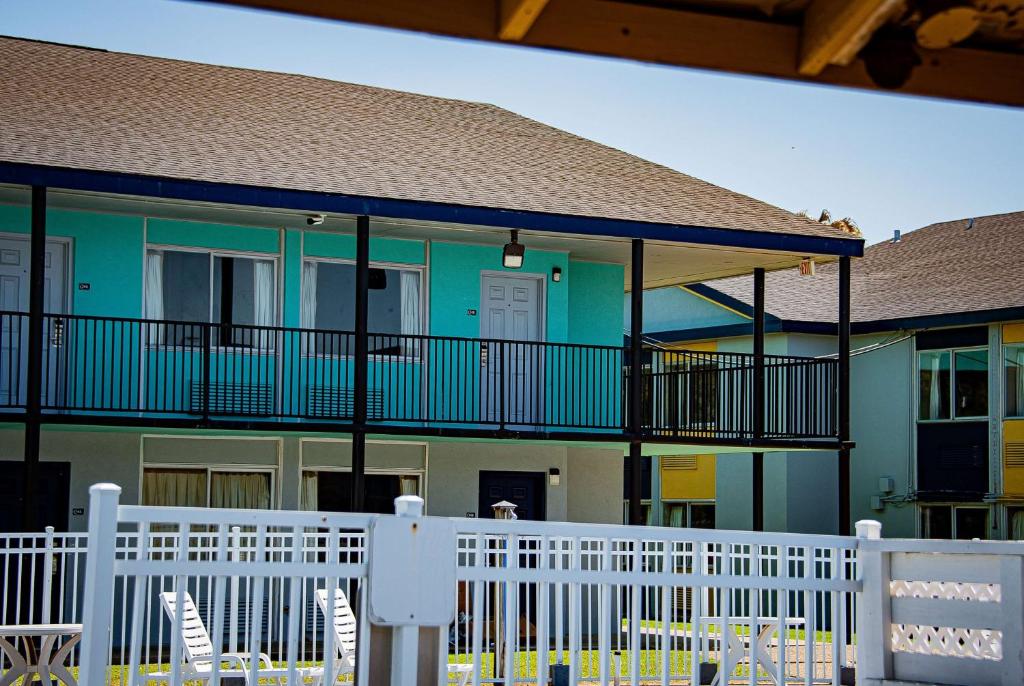 a building with chairs and a white fence at Super 8 by Wyndham Biloxi in Biloxi