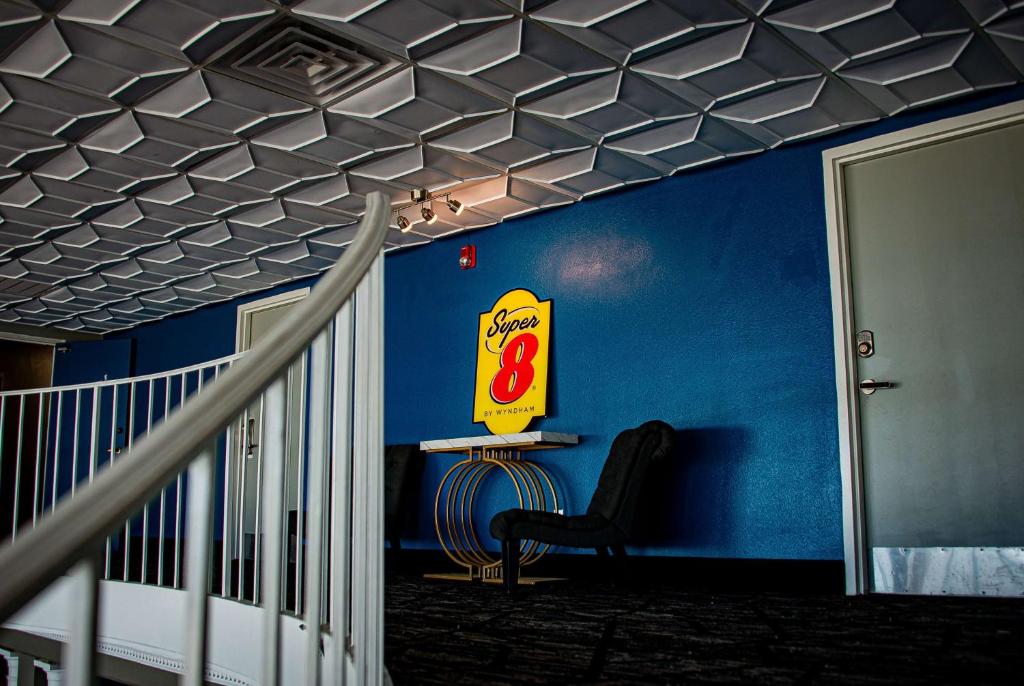 a room with a cola sign on a blue wall at Super 8 by Wyndham Biloxi in Biloxi