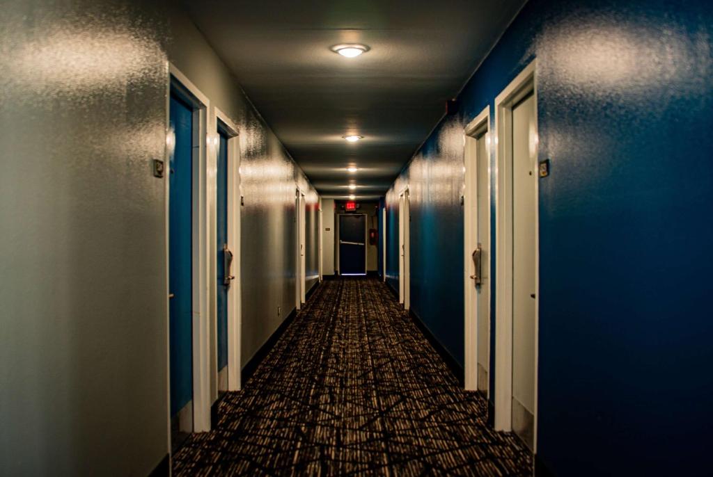 an empty hallway with blue walls and a long corridor at Super 8 by Wyndham Biloxi in Biloxi