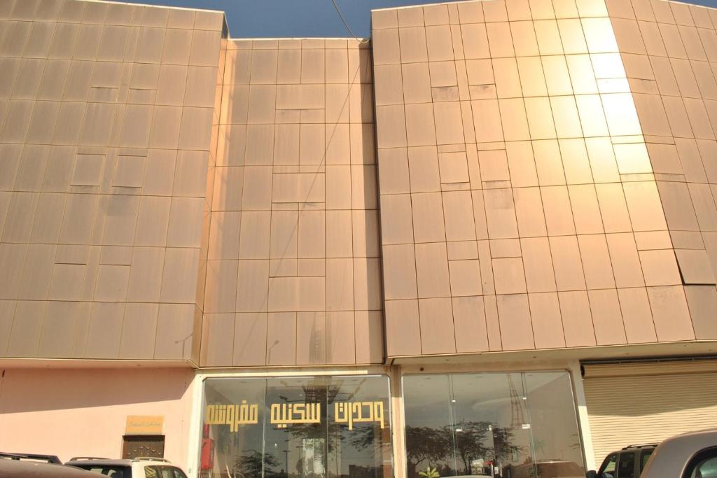 a building with cars parked in front of it at Golden Prince Hotel Al Fayizia in Buraydah