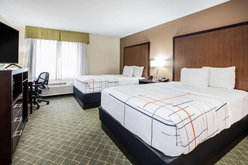 a hotel room with two beds and a television at La Quinta by Wyndham Portland Airport in Portland