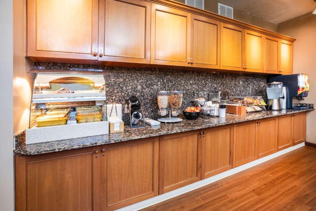 a kitchen with wooden cabinets and a counter with food at La Quinta by Wyndham Portland Airport in Portland