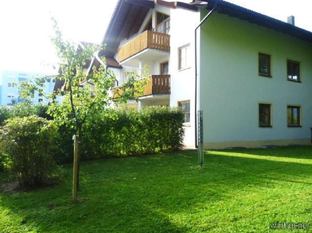 ein großes weißes Gebäude mit einem grünen Hof in der Unterkunft Ferienwohnung Utz in Zwiesel
