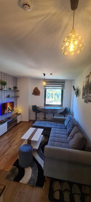 una sala de estar con un sofá y una mesa en Stars Apartman Jahorina, en Jahorina