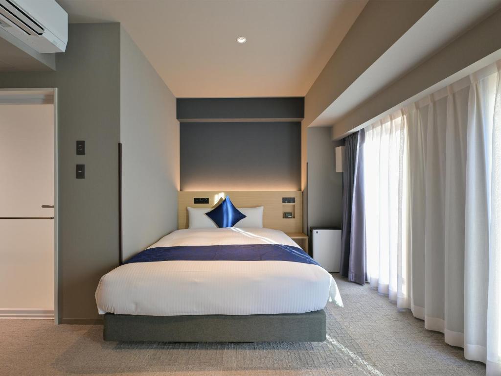 Postel nebo postele na pokoji v ubytování HOTEL R9 Premium Ichikawaekimae