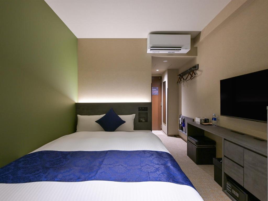 Postel nebo postele na pokoji v ubytování HOTEL R9 Premium Ichikawaekimae