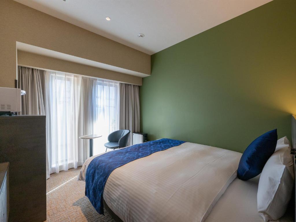 Postel nebo postele na pokoji v ubytování HOTEL R9 Premium Ichikawaekimae