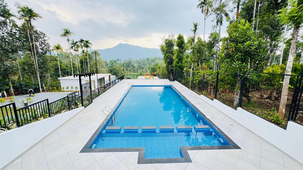 - une piscine dans une maison avec des arbres et des montagnes dans l'établissement locera resort, à Meppādi