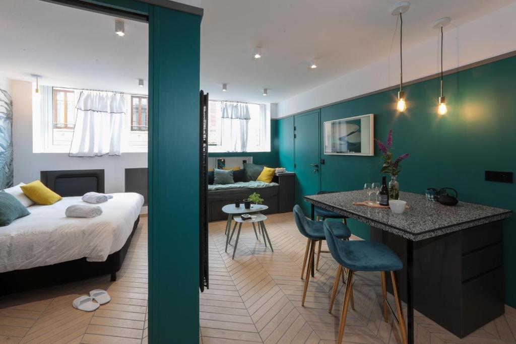 une chambre et un salon avec un lit et une table dans l'établissement City Astoria An urban appartement, à Aix-les-Bains