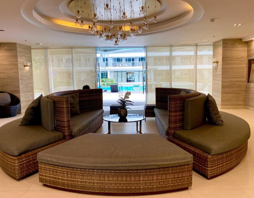 a living room with two couches and a table at FameStaycation at FAME Residences in Manila