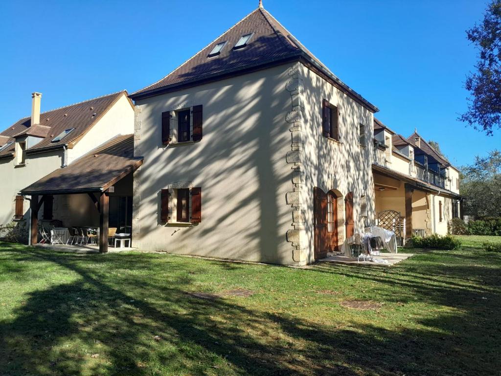 a large white building with a grass yard at Lilas - Spacieuse maison 10 pers Jardin BBQ in Doumen