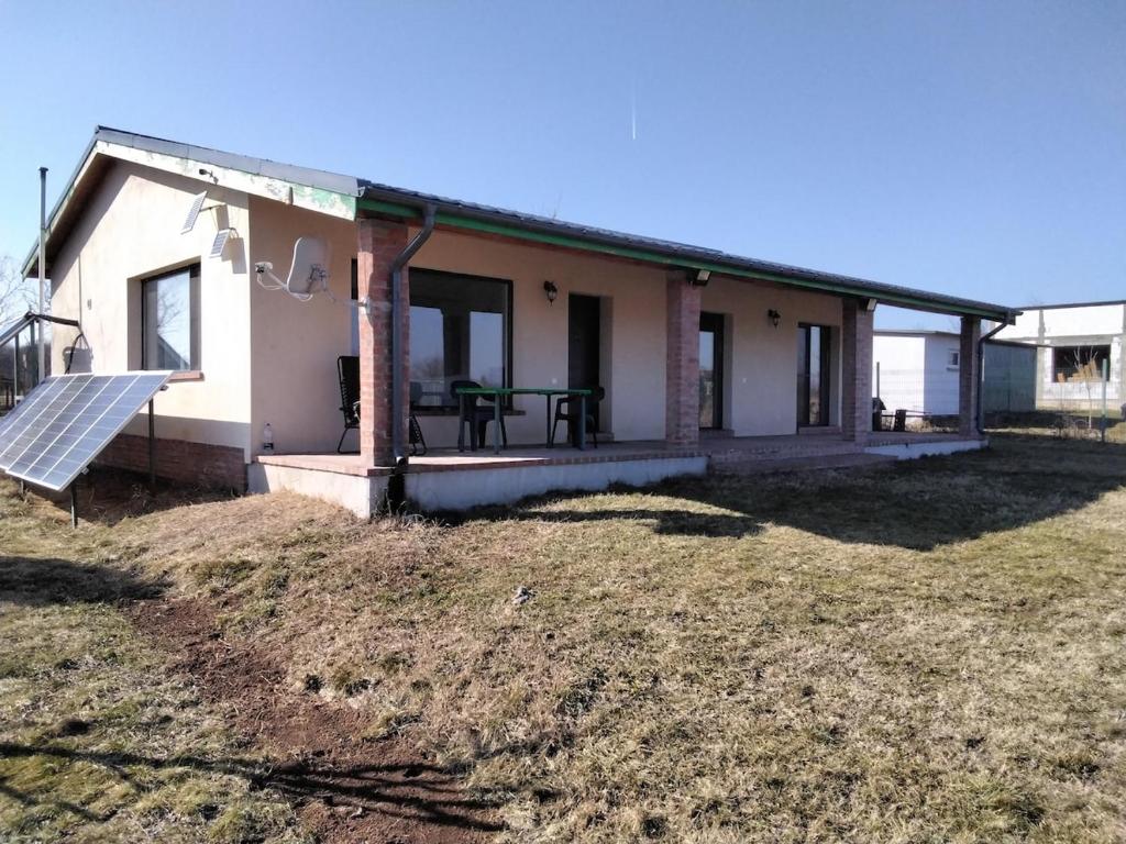 a house with a porch and a table on a yard at Vacanta snagov-ciolpani in Piscu