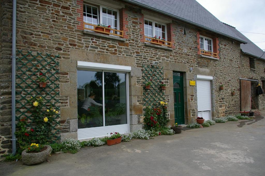 un edificio de ladrillo con una ventana y flores en él en Marie France 's home, en Sacey