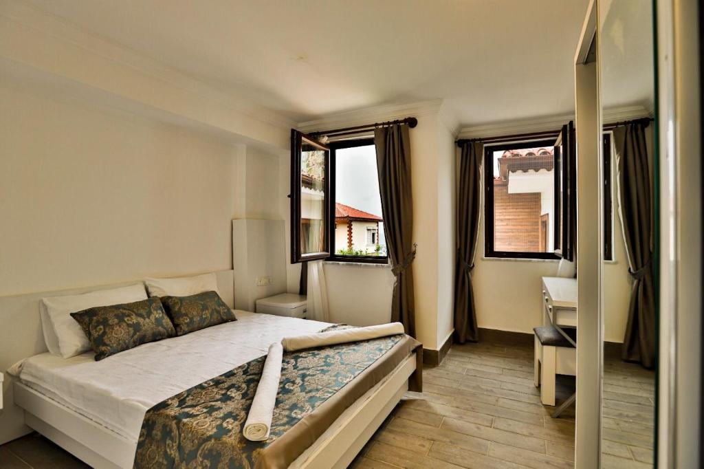 a bedroom with a bed and two windows at Orya Butik Otel in Side
