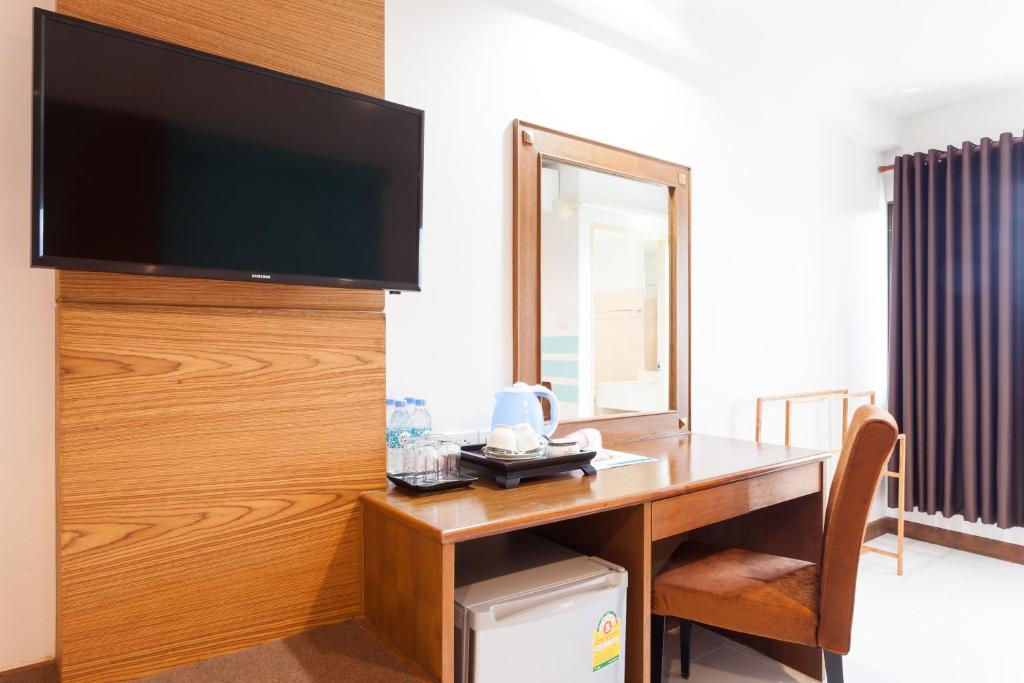 A wood desk beside the minibar provides a practical work and refreshment corner.