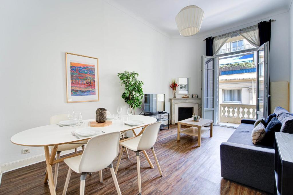 un salon avec une table et un canapé dans l'établissement L'Écrin Blanc Niçois - Welkeys, à Nice