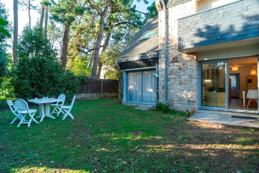 un patio avec une table et des chaises dans une cour dans l'établissement Men Guen - A 250 m de la plage, à Carnac