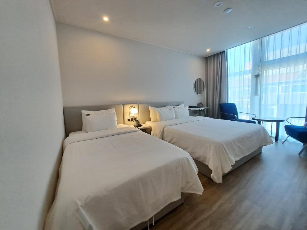 Postel nebo postele na pokoji v ubytování Ocean The Point Hotel Busan