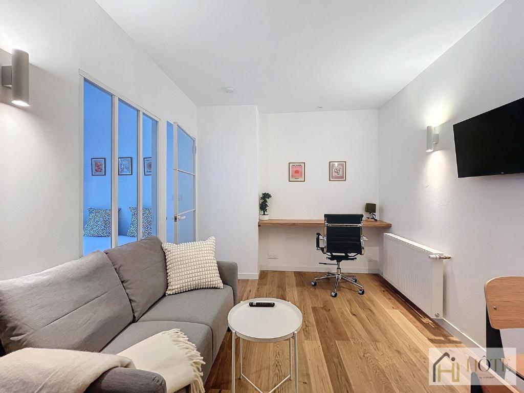 un salon avec un canapé et une chaise dans l'établissement Petit Cocon - Confort & Moderne, à Dunkerque