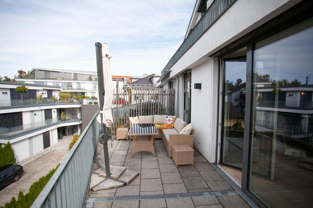 a balcony with a couch and chairs on a building at Luxury City Suite - Rosenheim in Rosenheim