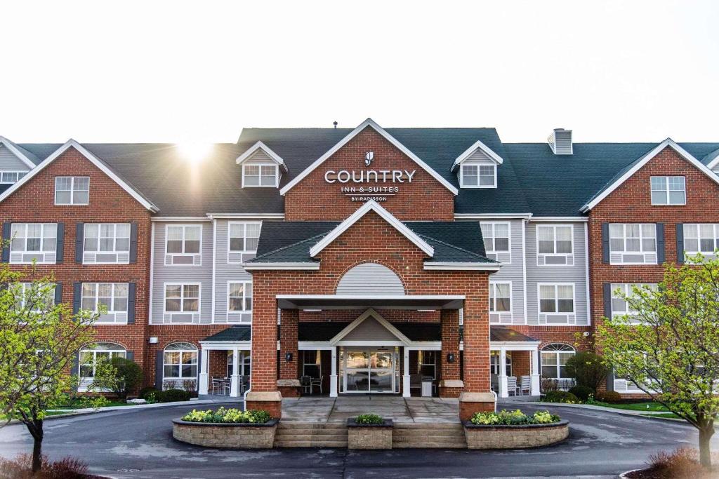 a large red brick building with a sign on it at Country Inn & Suites by Radisson, Milwaukee West Brookfield , WI in Brookfield