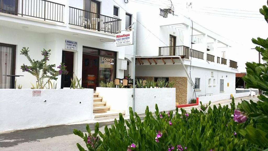 a white building with stairs and flowers in front of it at Milounapa in Ayia Napa