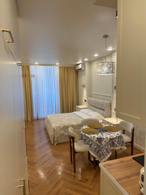 a bedroom with a bed and a table and a couch at NBG d 'amore Appart in Batumi