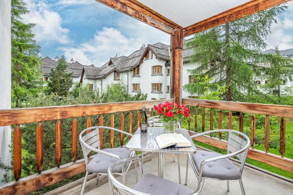 a table and chairs on the balcony of a house at Stylish apartment with hotel spa in Lenzerheide
