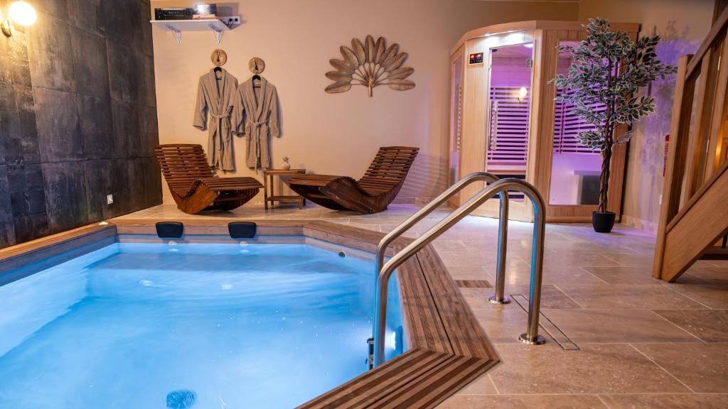 een hot tub in een kamer met stoelen en een tafel bij Evaziona in Blairville