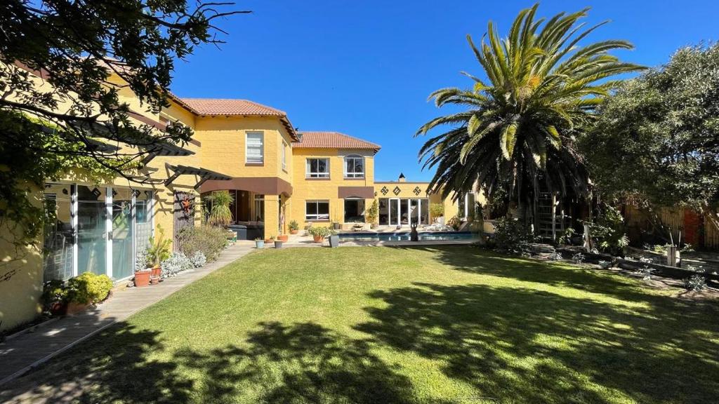 a large yard with a palm tree and a house at Sunset Retreat in Cape Town