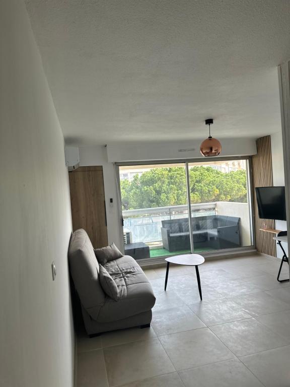 un salon avec un canapé et une table dans l'établissement Magnifique Studio, à Mauguio