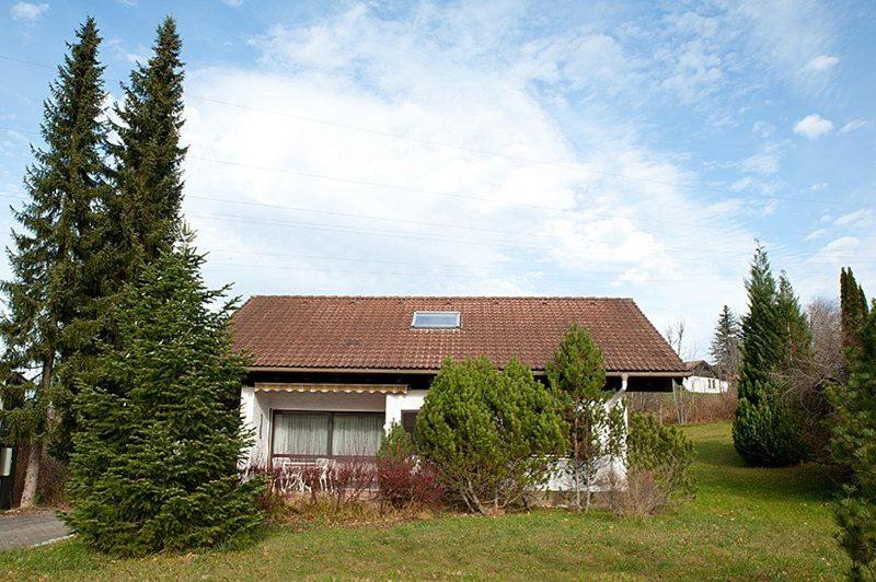 a house with a brown roof and some trees at Ferienhaus Gamssteige im Feriendorf Reichenbach G11 in Nesselwang