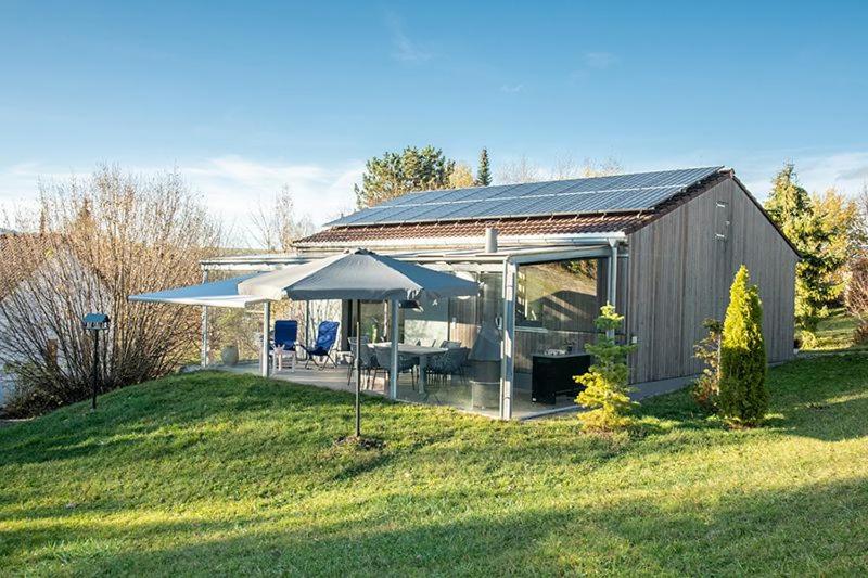 a barn with a table and chairs and umbrellas at Ferienhaus Gamssteige im Feriendorf Reichenbach G29 in Nesselwang